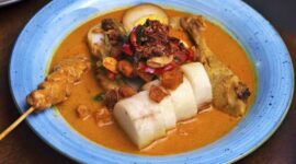 Semangkuk bubur pedas khas Singkawang yang kaya rempah dan sayuran segar, siap memanjakan lidah dengan cita rasa uniknya. Taburan teri dan kacang tanah renyah menambah tekstur yang menggugah selera.