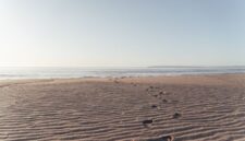 Jejak kaki di hamparan pasir pantai saat matahari terbenam menciptakan siluet indah yang seringkali menjadi simbol kedamaian dan kebebasan. Pemandangan ini mengingatkan kita akan keindahan alam yang tak ternilai dan pentingnya menjaganya.