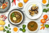 Semangkuk bubur pedas khas Indonesia dengan taburan bawang goreng dan pelengkap lainnya, siap menggoda selera dengan aroma rempah yang kuat dan cita rasa pedas yang khas. Hidangan ini menunjukkan kekayaan kuliner Nusantara yang berani bermain dengan spektrum rasa.
