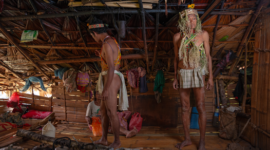 Seorang tetua adat Dayak Kanayatn memimpin ritual sakral di tengah perkampungan mereka, menunjukkan dedikasi mendalam terhadap warisan leluhur dan menjaga keseimbangan spiritual dengan alam. Pemandangan ini mencerminkan kekuatan tradisi yang terus hidup dalam kehidupan sehari-hari masyarakat Dayak Kanayatn.