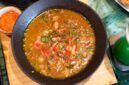 Semangkuk bubur pedas khas Indonesia yang hangat dan kaya rempah, dihiasi dengan irisan telur, bawang goreng, serta kerupuk renyah, siap menggugah selera dan menghadirkan sensasi pedas yang membakar. Hidangan ini memadukan tekstur lembut bubur dengan bumbu pedas yang intens, menciptakan pengalaman makan yang tak terlupakan.