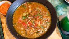 Semangkuk bubur pedas khas Indonesia yang hangat dan kaya rempah, dihiasi dengan irisan telur, bawang goreng, serta kerupuk renyah, siap menggugah selera dan menghadirkan sensasi pedas yang membakar. Hidangan ini memadukan tekstur lembut bubur dengan bumbu pedas yang intens, menciptakan pengalaman makan yang tak terlupakan.
