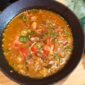Semangkuk bubur pedas khas Indonesia yang hangat dan kaya rempah, dihiasi dengan irisan telur, bawang goreng, serta kerupuk renyah, siap menggugah selera dan menghadirkan sensasi pedas yang membakar. Hidangan ini memadukan tekstur lembut bubur dengan bumbu pedas yang intens, menciptakan pengalaman makan yang tak terlupakan.