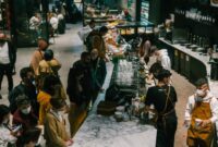 Suasana hangat dan akrab di sebuah kafe modern, di mana berbagai individu menemukan kedamaian dan koneksi melalui secangkir kopi. Gambar ini menunjukkan bagaimana kopi menjadi bagian tak terpisahkan dari interaksi sosial dan relaksasi di tengah kesibukan kota.