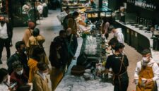 Suasana hangat dan akrab di sebuah kafe modern, di mana berbagai individu menemukan kedamaian dan koneksi melalui secangkir kopi. Gambar ini menunjukkan bagaimana kopi menjadi bagian tak terpisahkan dari interaksi sosial dan relaksasi di tengah kesibukan kota.