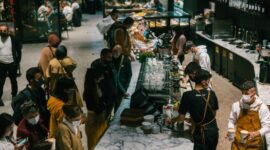 Suasana hangat dan akrab di sebuah kafe modern, di mana berbagai individu menemukan kedamaian dan koneksi melalui secangkir kopi. Gambar ini menunjukkan bagaimana kopi menjadi bagian tak terpisahkan dari interaksi sosial dan relaksasi di tengah kesibukan kota.
