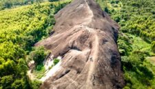 Pemandangan udara Bukit Kelam yang menjulang sendirian di tengah hamparan dataran hijau, memperlihatkan keagungan monolit alami ini dari sudut pandang yang menakjubkan. Bentuknya yang unik dan ukurannya yang masif menjadikan Bukit Kelam ikon alam yang tak terlupakan di Kalimantan Barat.