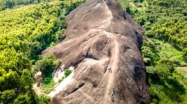 Pemandangan udara Bukit Kelam yang menjulang sendirian di tengah hamparan dataran hijau, memperlihatkan keagungan monolit alami ini dari sudut pandang yang menakjubkan. Bentuknya yang unik dan ukurannya yang masif menjadikan Bukit Kelam ikon alam yang tak terlupakan di Kalimantan Barat.