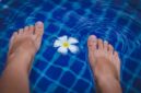 Seorang wanita sedang melakukan gerakan aqua aerobik di kolam renang, menikmati manfaat dari latihan air yang minim tekanan pada sendi namun tetap efektif membakar kalori. Aktivitas ini cocok untuk segala usia dan kondisi fisik, menawarkan cara menyegarkan untuk menjaga kebugaran tubuh.
