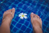 Seorang wanita sedang melakukan gerakan aqua aerobik di kolam renang, menikmati manfaat dari latihan air yang minim tekanan pada sendi namun tetap efektif membakar kalori. Aktivitas ini cocok untuk segala usia dan kondisi fisik, menawarkan cara menyegarkan untuk menjaga kebugaran tubuh.