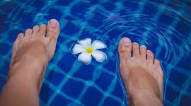 Seorang wanita sedang melakukan gerakan aqua aerobik di kolam renang, menikmati manfaat dari latihan air yang minim tekanan pada sendi namun tetap efektif membakar kalori. Aktivitas ini cocok untuk segala usia dan kondisi fisik, menawarkan cara menyegarkan untuk menjaga kebugaran tubuh.