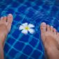 Seorang wanita sedang melakukan gerakan aqua aerobik di kolam renang, menikmati manfaat dari latihan air yang minim tekanan pada sendi namun tetap efektif membakar kalori. Aktivitas ini cocok untuk segala usia dan kondisi fisik, menawarkan cara menyegarkan untuk menjaga kebugaran tubuh.