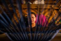 Para perempuan Suku Dayak Kanayatn dengan bangga memamerkan kain tenun tradisional hasil karya tangan mereka yang indah, mencerminkan kekayaan warisan budaya serta keahlian yang telah diwariskan secara turun-temurun. Setiap motif kain memiliki cerita dan makna mendalam yang merefleksikan identitas serta pandangan hidup masyarakat Kanayatn.