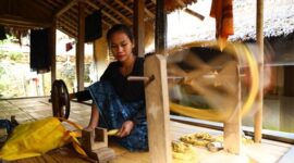Seorang model mengenakan busana modern berbahan tenun ikat dengan motif geometris yang menawan, menunjukkan bagaimana warisan budaya Indonesia dapat berpadu apik dalam tren fesyen kontemporer. Penampilan ini merefleksikan keindahan dan fleksibilitas tenun ikat untuk berbagai gaya hidup.