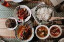 Semangkuk Bubur Pedas khas Kalimantan Barat yang mengepul hangat, siap memanjakan lidah dengan perpaduan rempah eksotis dan sensasi pedas yang membakar, dihiasi aneka sayuran segar serta taburan ikan teri dan kacang. Hidangan ini menunjukkan kekayaan warisan kuliner Nusantara yang patut dibanggakan.