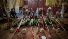 Upacara adat masyarakat Dayak Kanayatn di depan rumah tradisional, menunjukkan kekayaan budaya dan spiritualitas mereka yang erat kaitannya dengan alam. Mereka menjaga tradisi leluhur dengan penuh hormat.