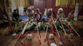 Upacara adat masyarakat Dayak Kanayatn di depan rumah tradisional, menunjukkan kekayaan budaya dan spiritualitas mereka yang erat kaitannya dengan alam. Mereka menjaga tradisi leluhur dengan penuh hormat.