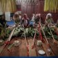 Upacara adat masyarakat Dayak Kanayatn di depan rumah tradisional, menunjukkan kekayaan budaya dan spiritualitas mereka yang erat kaitannya dengan alam. Mereka menjaga tradisi leluhur dengan penuh hormat.