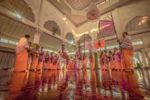 Seorang penenun wanita dengan teliti menciptakan motif pada kain songket, menunjukkan dedikasi tinggi dalam melestarikan warisan budaya Melayu yang kaya akan nilai dan estetika. Proses ini membutuhkan kesabaran luar biasa untuk menghasilkan mahakarya tekstil yang indah serta memiliki makna mendalam.