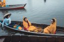 Perahu tradisional melintasi aliran Sungai Kapuas yang tenang, dikelilingi rimbunnya hutan hujan tropis Kalimantan, menunjukkan harmoni antara manusia dan alam.