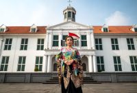 Model mengenakan busana modern dengan sentuhan tenun ikat tradisional, menunjukkan perpaduan apik antara warisan budaya dan gaya kontemporer yang relevan. Keindahan motif tenun ikat memberikan kesan elegan pada koleksi fesyen terkini.