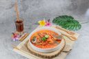 Semangkuk bubur pedas khas Singkawang dengan taburan kacang tanah, ikan teri, dan beragam sayuran segar yang siap memanjakan lidah Anda dengan cita rasa unik dan pedas yang menghangatkan. Hidangan ini merupakan perpaduan sempurna antara kekayaan rempah dan tekstur yang beragam.