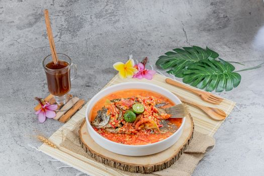Semangkuk bubur pedas khas Singkawang dengan taburan kacang tanah, ikan teri, dan beragam sayuran segar yang siap memanjakan lidah Anda dengan cita rasa unik dan pedas yang menghangatkan. Hidangan ini merupakan perpaduan sempurna antara kekayaan rempah dan tekstur yang beragam.