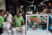 Semangkuk bubur pedas khas Pontianak dengan taburan kacang, ikan teri, dan irisan sayuran hijau, siap menggugah selera dengan cita rasa rempah yang kaya dan pedasnya yang menghangatkan. Hidangan ini merupakan perpaduan sempurna antara kelembutan bubur dan kekuatan bumbu tradisional Indonesia.