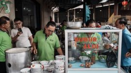 Semangkuk bubur pedas khas Pontianak dengan taburan kacang, ikan teri, dan irisan sayuran hijau, siap menggugah selera dengan cita rasa rempah yang kaya dan pedasnya yang menghangatkan. Hidangan ini merupakan perpaduan sempurna antara kelembutan bubur dan kekuatan bumbu tradisional Indonesia.