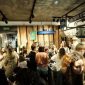 Suasana hangat di sebuah kedai kopi modern, tempat para pengunjung berkumpul untuk bekerja, berdiskusi, atau sekadar menikmati secangkir kopi racikan barista. Kopi telah menjadi medium esensial yang mempertemukan berbagai individu dan ide.